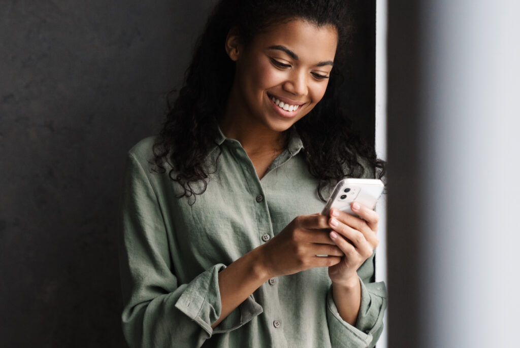 Smiling woman using mobile phone