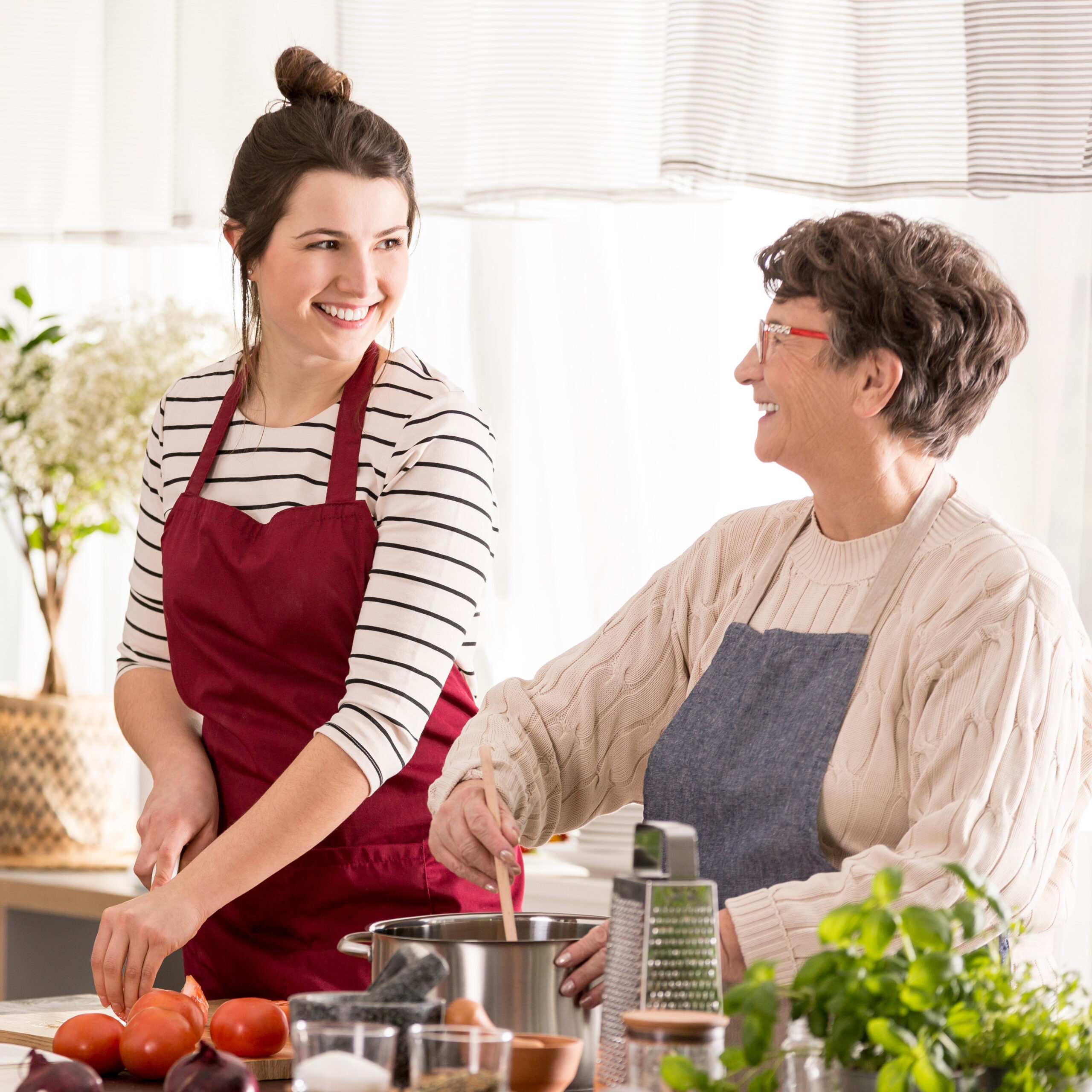 Smiling women cooking dinner together