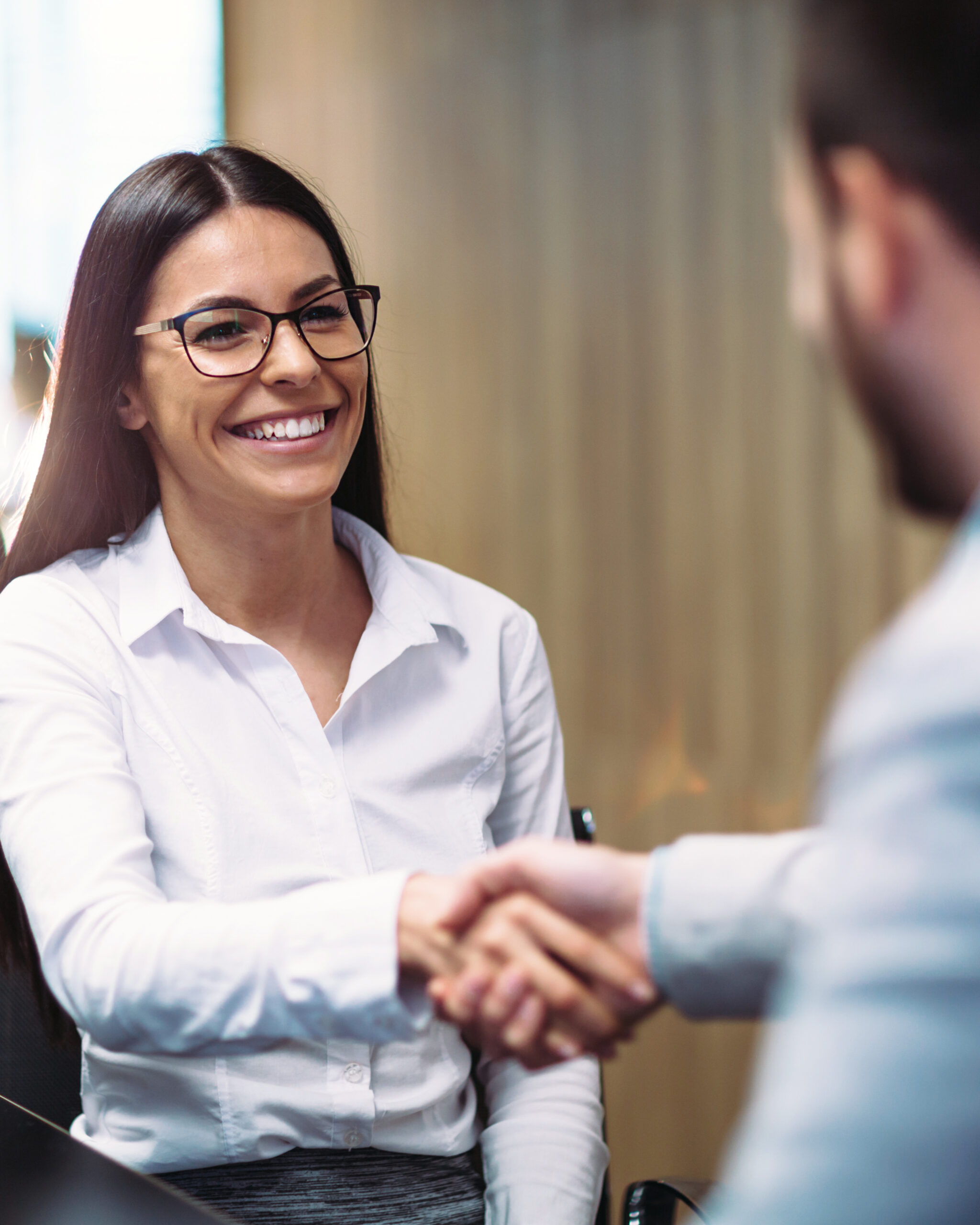 Smiling professional woman shaking hands with someone 